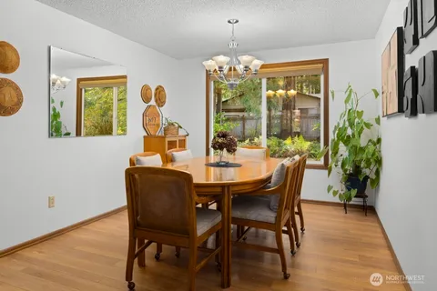 a dining room with furniture a chandelier and wooden floor