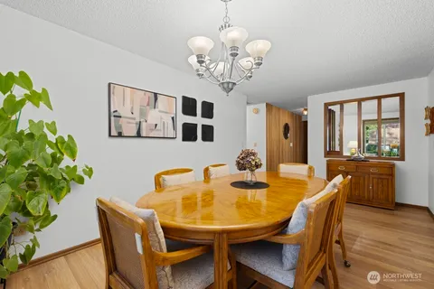a dining room with furniture potted plants and wooden floor