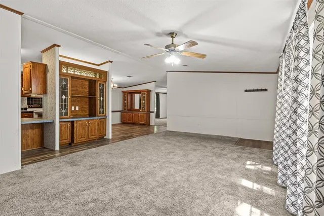 a view of an empty room with window and cabinet