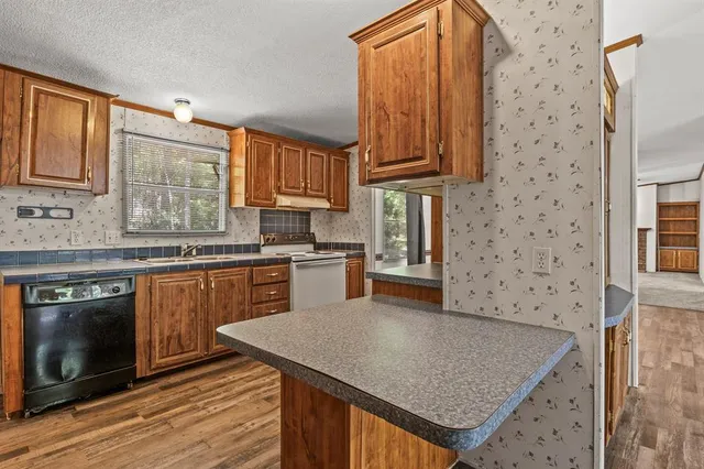 a kitchen with stainless steel appliances granite countertop a sink stove and cabinets
