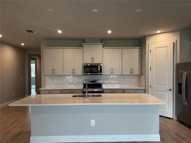 a kitchen with a appliances a sink and a cabinets