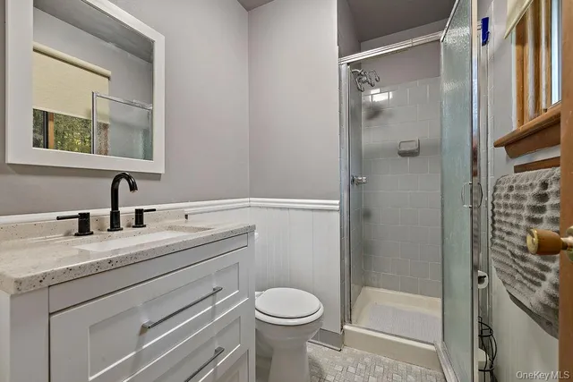 a bathroom with a granite countertop toilet and a sink