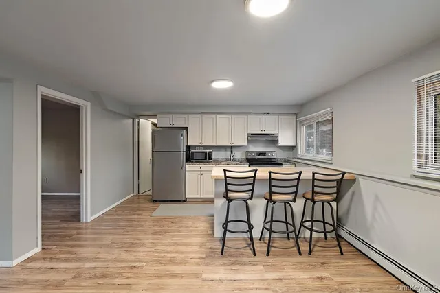 a view of a room with wooden floor and a window