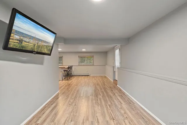 a kitchen with white cabinets and wooden floor