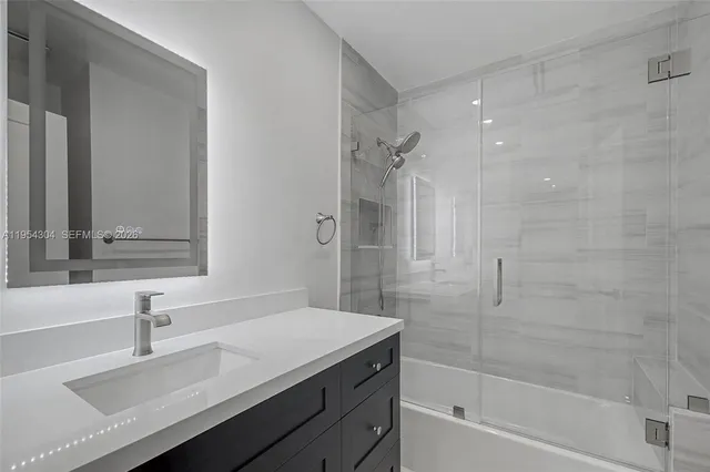 a bathroom with a granite countertop sink a toilet and shower