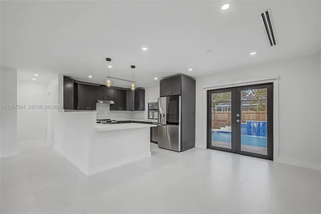 a kitchen with stainless steel appliances kitchen island granite countertop a refrigerator and a stove top oven