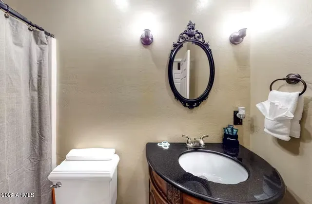 a bathroom with a toilet a sink and a mirror