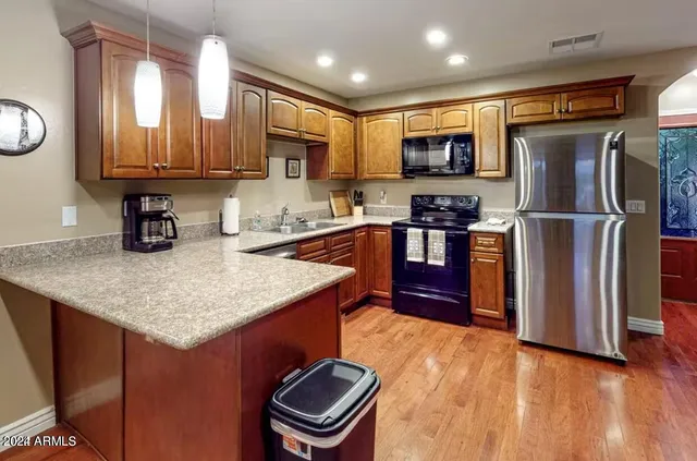 a kitchen with stainless steel appliances granite countertop a sink a stove and a refrigerator