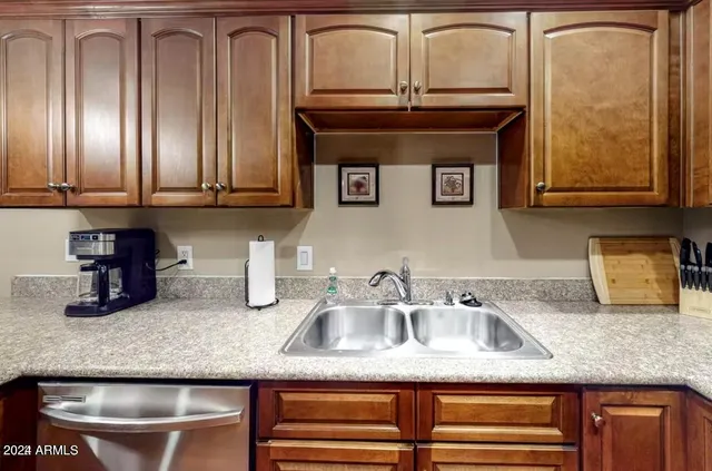 a kitchen with granite countertop a sink a stove and cabinets