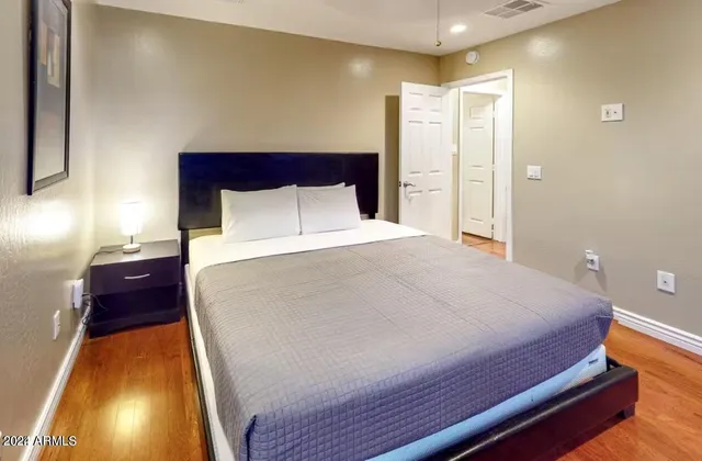 a large bed sitting in a room next to a lamp