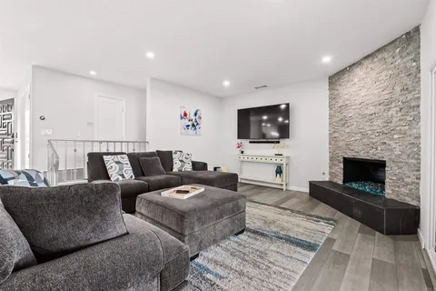 a living room with furniture a flat screen tv and a fireplace