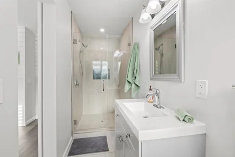 a bathroom with a sink a mirror and a shower