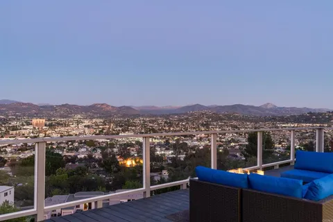a view of city from a balcony with a floor to ceiling window