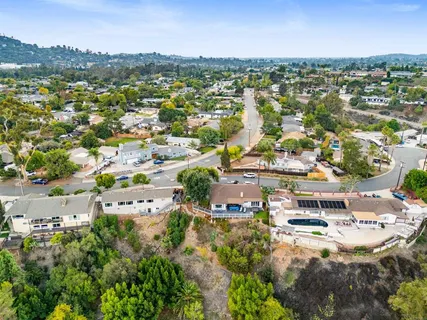 an aerial view of residential houses with outdoor space and trees