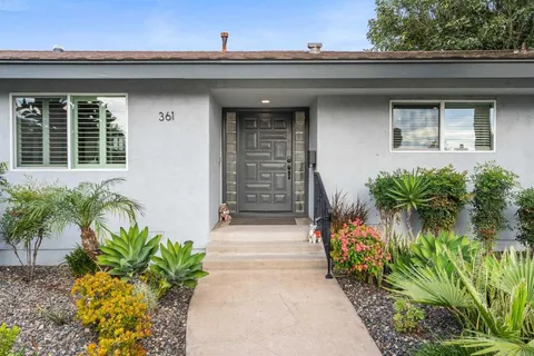 a front view of a house with a garden