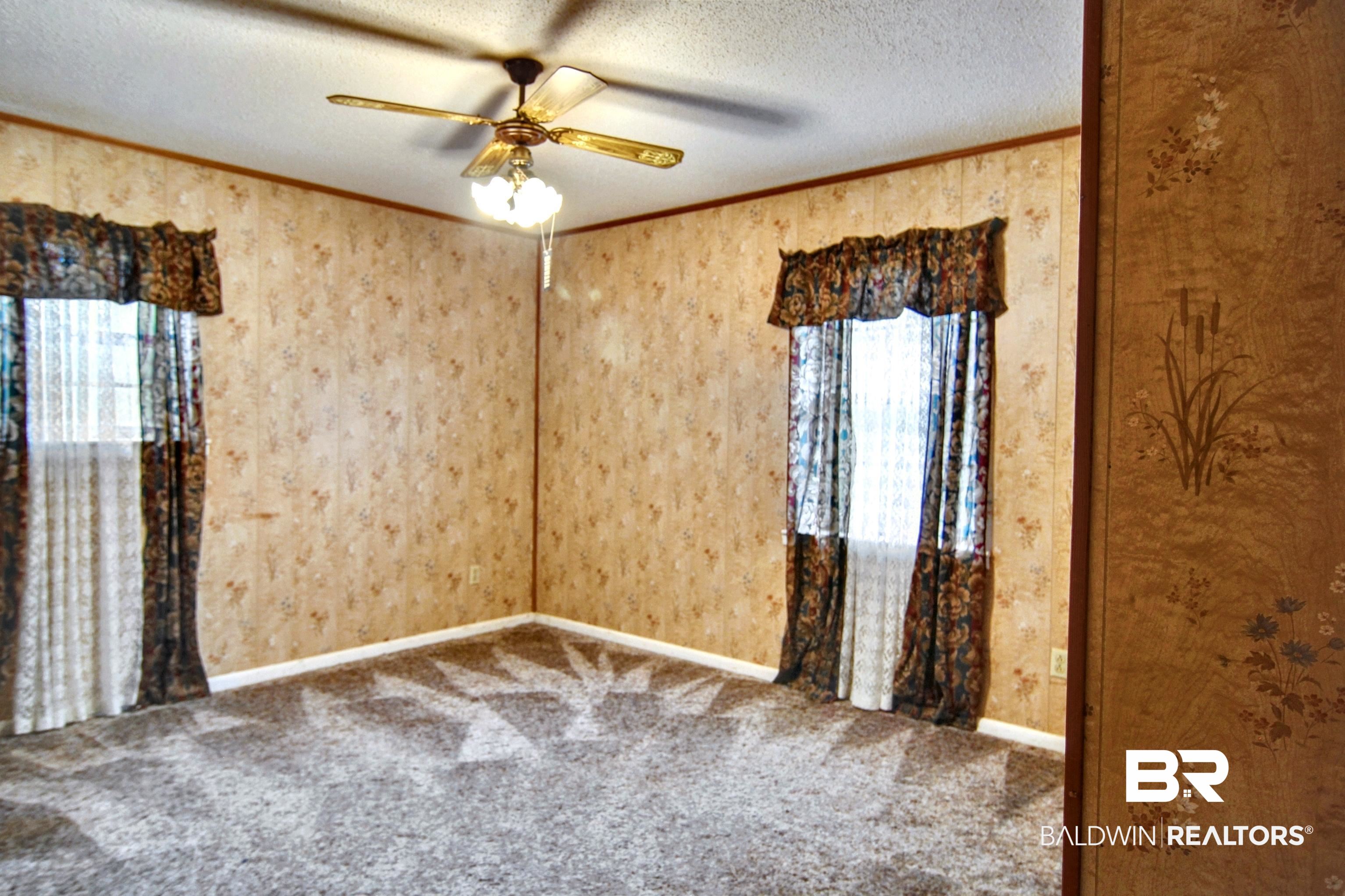 12897 County Road 65 Foley, AL 36535 - Photo 8 of 21 Carpeted spare room featuring crown molding, ceiling fan, and a textured ceiling