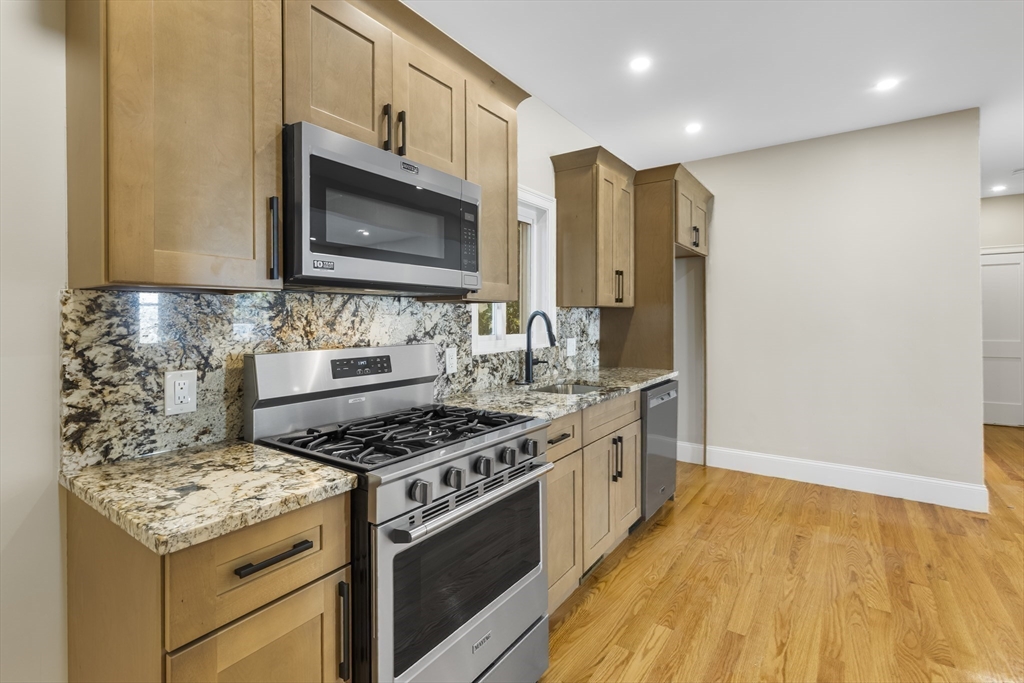 a kitchen with stainless steel appliances granite countertop a stove and a microwave