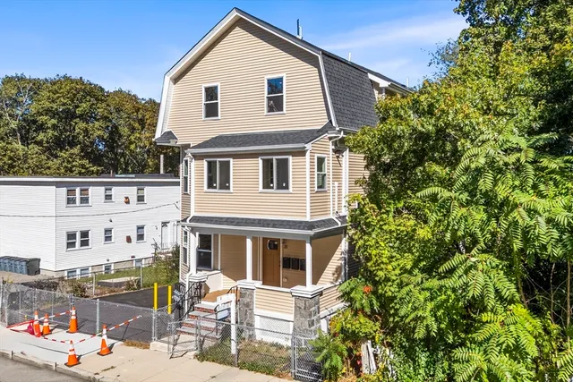 a front view of a house with a tree