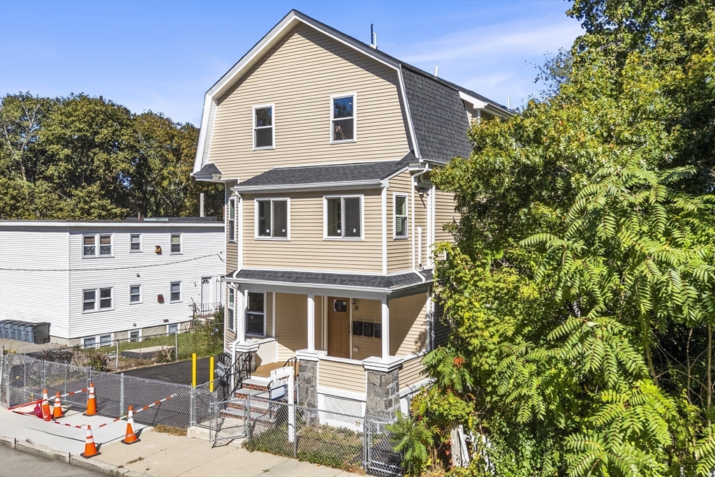 31 Woodale Avenue, Unit 1 Boston, MA 02126 - Photo 21 of 22 a front view of a house with a tree