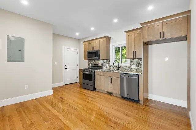 a kitchen with a refrigerator and a stove top oven