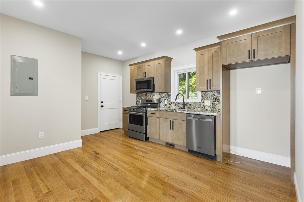 31 Woodale Avenue, Unit 1 Boston, MA 02126 - Photo 3 of 22 a kitchen with a refrigerator and a stove top oven