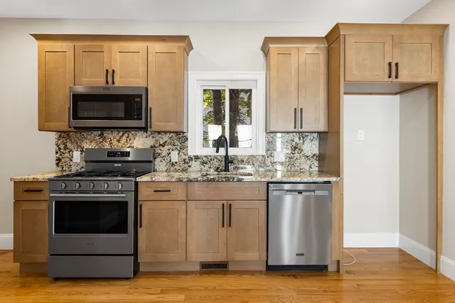a kitchen with stainless steel appliances granite countertop a stove a sink and a microwave