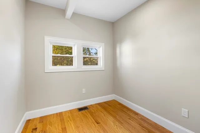 a view of a room with wooden floor and a window