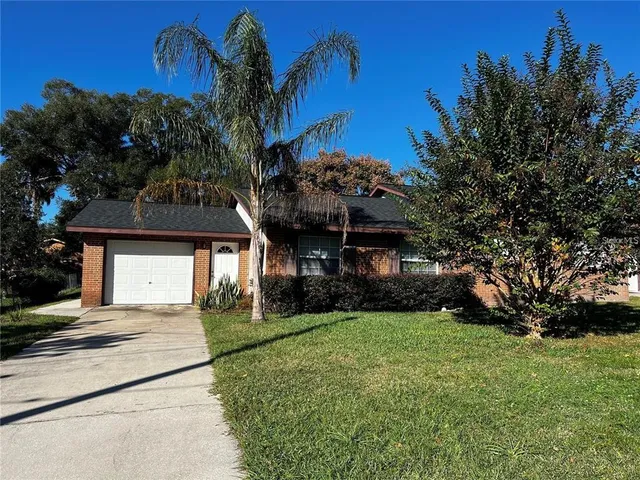 a front view of a house with a garden and trees