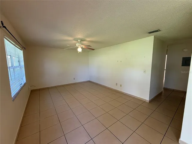 an empty room with a empty space and chandelier fan