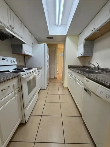 a kitchen with a stove top oven cabinets and stainless steel appliances