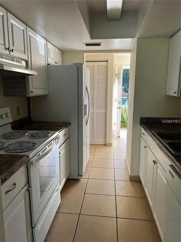 a kitchen with a stove a refrigerator and cabinets