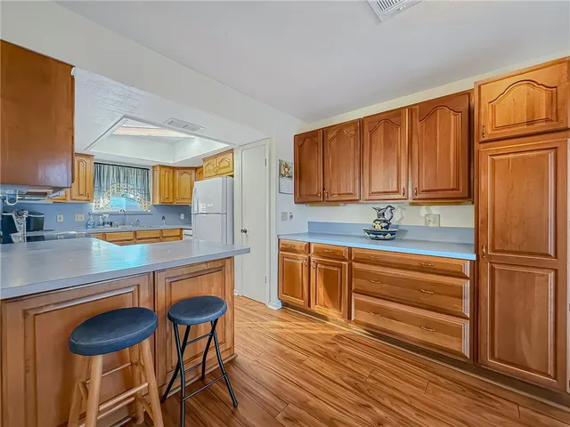 a kitchen with granite countertop wooden cabinets and white appliances