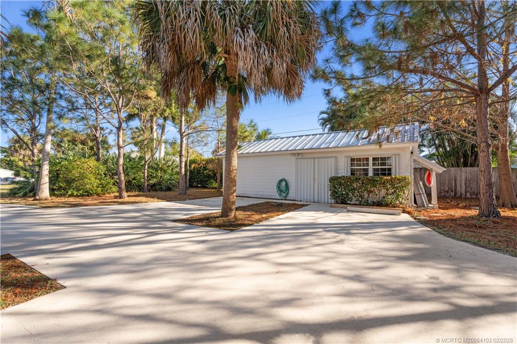 900 Northwest 11th Terrace Stuart, FL 34994 - Photo 11 of 35 a view of a white house next to a road and palm trees