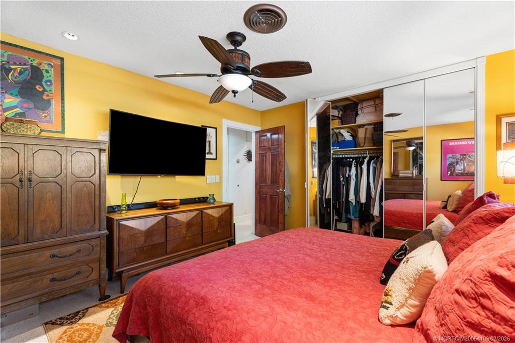 900 Northwest 11th Terrace Stuart, FL 34994 - Photo 12 of 35 a bedroom with a bed and a flat screen tv