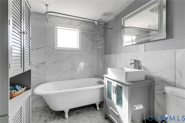 a bathroom with a tub a sink and a window