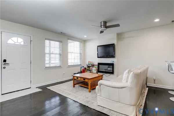 a living room with furniture a flat screen tv and a window