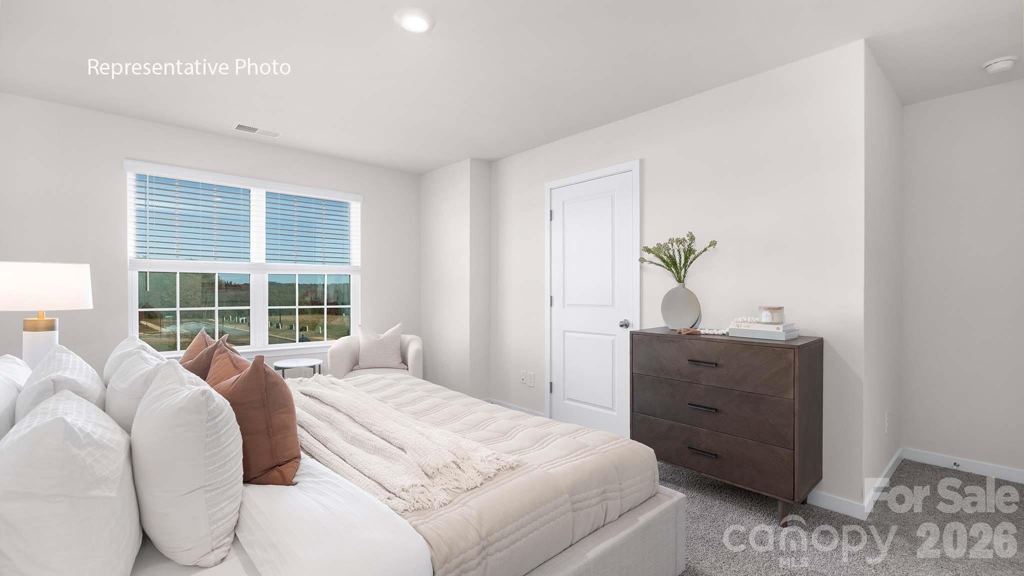 107 Parmiter Way, Unit B Troutman, NC 28166 - Photo 15 of 22 a bed room with a bed and a window