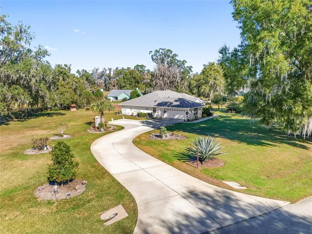 a aerial view of a house with swimming pool and large trees