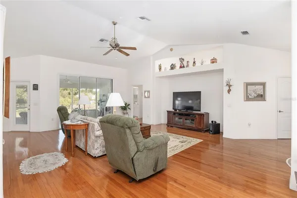 a kitchen with white cabinets and wooden floor