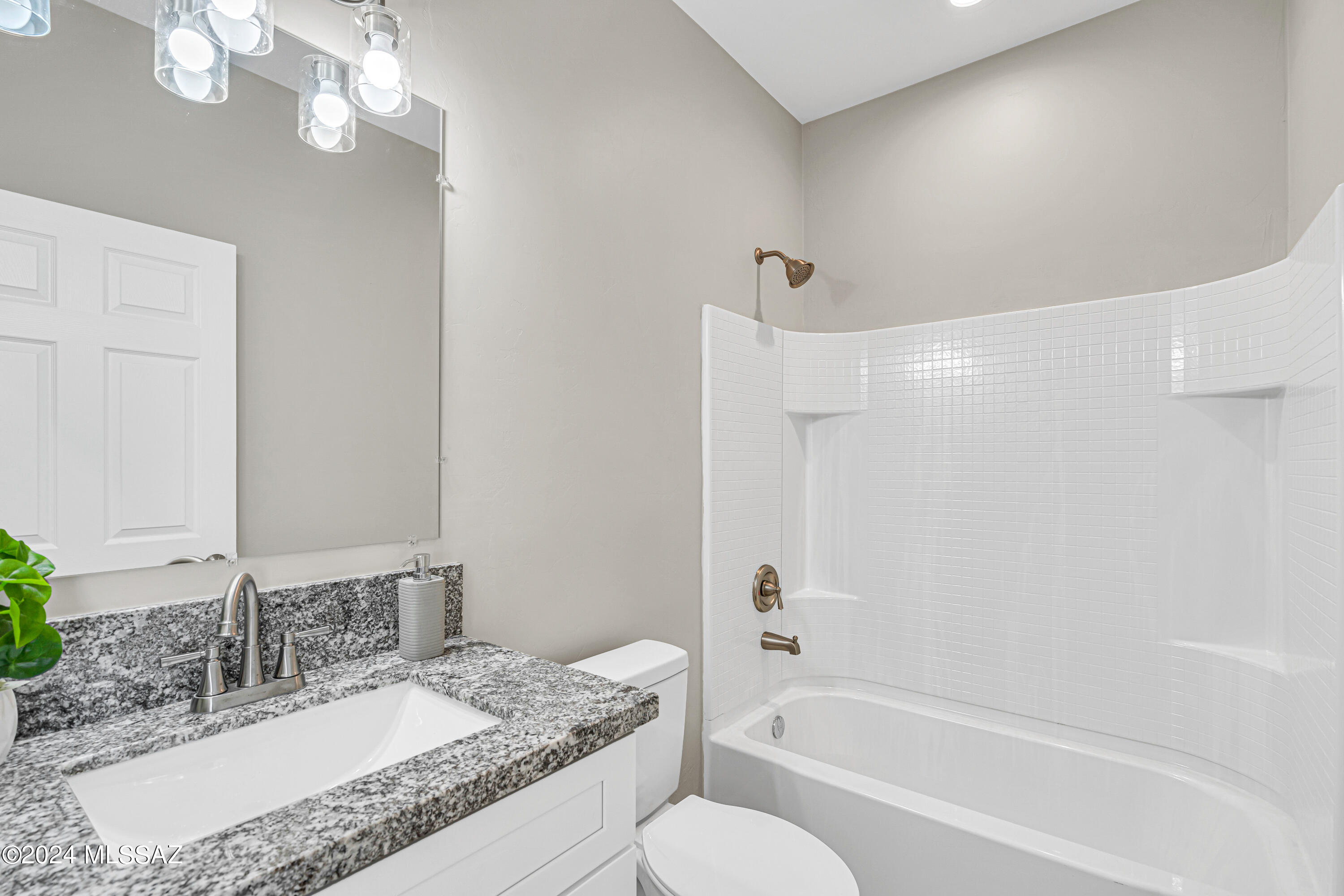 103 Headge Court Rio Rico, AZ 85648 - Photo 14 of 35 a bathroom with a granite countertop sink a toilet and bathtub