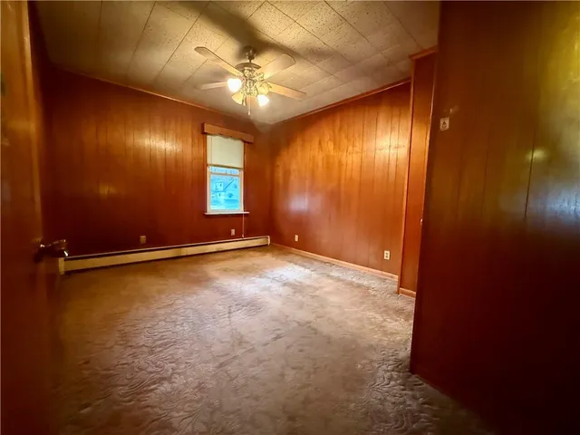 a view of an empty room with a chandelier fan