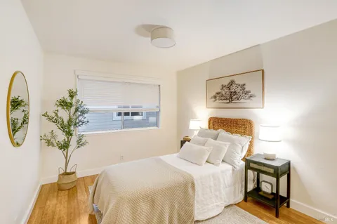 a bedroom with a bed and a painting on the wall