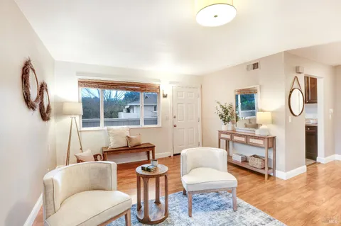 a living room with furniture a large window and a chandelier