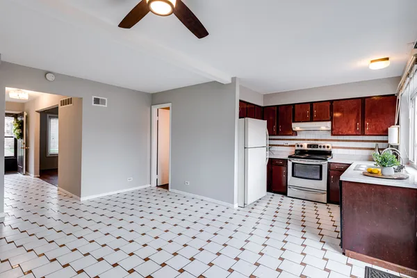 a kitchen with granite countertop a refrigerator and a stove top oven