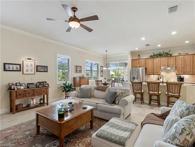 a living room with furniture kitchen view and a window
