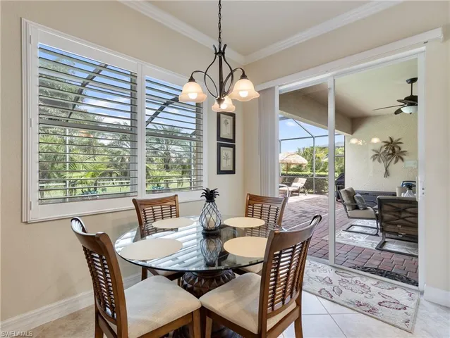 a dining room with furniture large windows and a chandelier