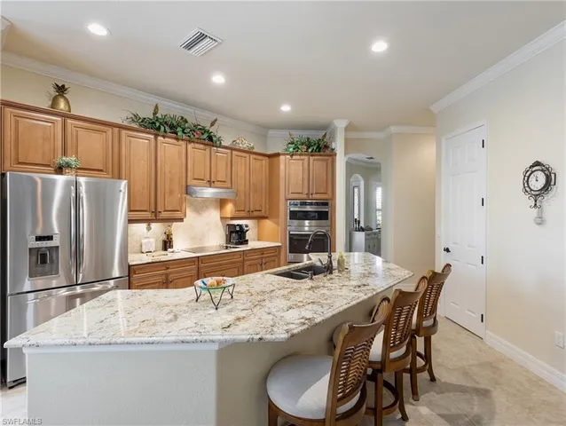a kitchen with stainless steel appliances granite countertop a sink refrigerator and cabinets