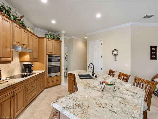 a kitchen with stainless steel appliances kitchen island granite countertop a refrigerator and a stove top oven