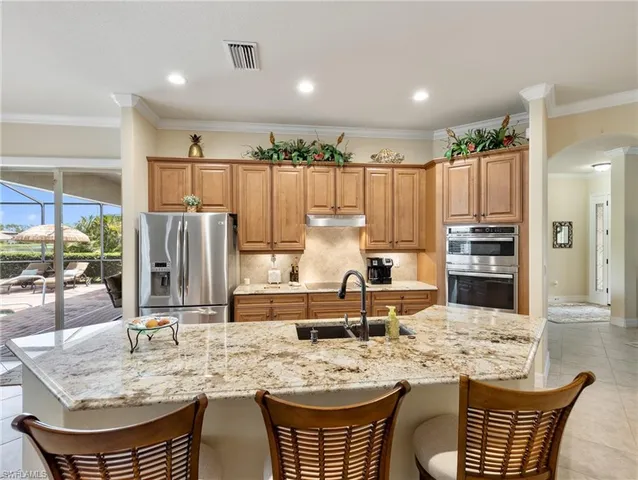 a kitchen with stainless steel appliances granite countertop a stove a sink and a refrigerator
