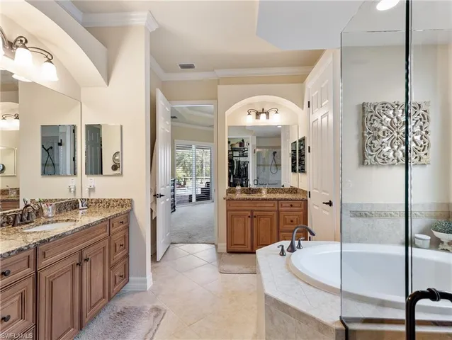 a large spacious bathroom with a granite countertop sink mirror and bathtub